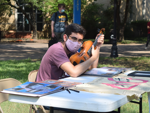 Photo of student wearing a mask and holding a violin at Austin College
